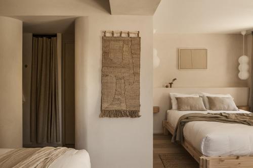 a white bedroom with two beds and a window at Maison Meraka - Design Guest House of Saint Emilion in Saint-Laurent-des-Combes