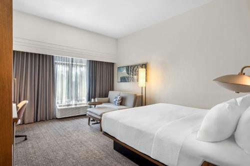 a hotel room with a bed and a chair at Courtyard by Marriott St. Augustine I-95 in St. Augustine