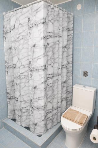a bathroom with a toilet and a shower curtain at Calithera in Samothraki
