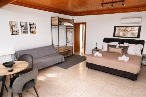 a bedroom with a bed and a couch and a table at Calithera in Samothraki