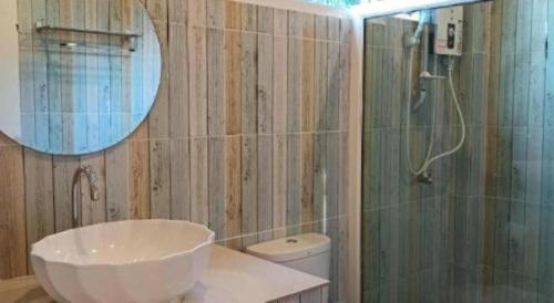 a bathroom with a sink and a mirror and a shower at Charisma Resort in Suan Phung