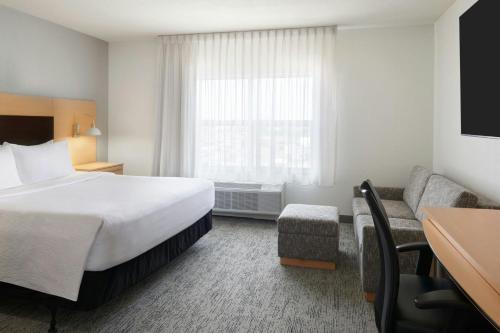 a hotel room with a bed and a couch at TownePlace Suites by Marriott Thunder Bay in Thunder Bay