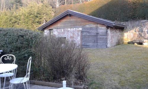 a wooden shed with a table and chairs in a yard at Romantic Studio Vacances in Labaroche