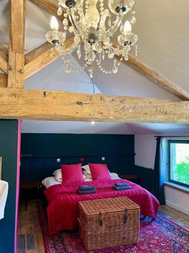 a bedroom with a large bed with a chandelier at La Rive Chambre d hôtes The Riverside Retreat in Jarnac