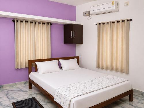 a bed in a room with purple and white at Leland Homestay in Mararikulam