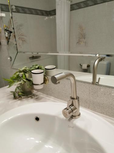 a bathroom sink with a faucet and a mirror at Spring Harmony Trikala Pigi in Tríkala