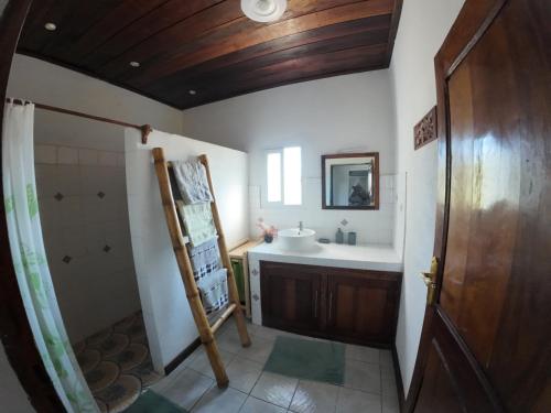 a bathroom with a sink and a toilet and a mirror at Le tournesol Belle villa in Maroantsetra Airport