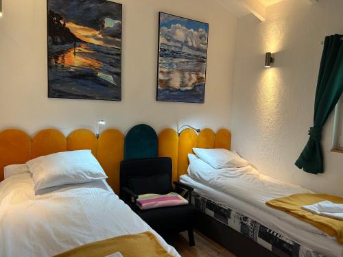 a room with two beds and a chair at Domki Przy Pracowni in Wytowno