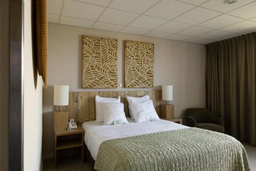 een hotelkamer met een bed en een stoel bij Forest Hotel in Den Helder