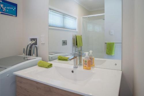a white bathroom with a sink and a mirror at Brougham Street B and B in Nelson
