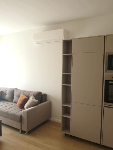 a living room with a couch and a book shelf at AH Home Delux Centar in Sarajevo