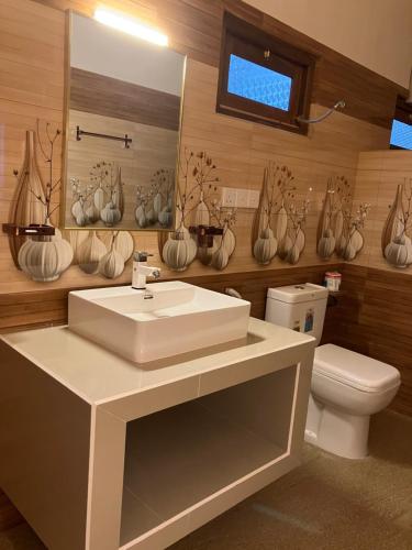 a bathroom with a white sink and a toilet at Aki Villa in Pasikuda