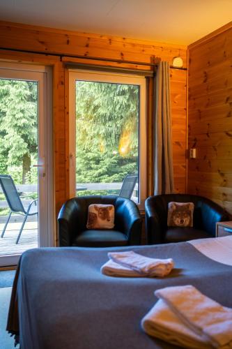 a room with a bed and two chairs and a window at Nature Resort Tiveden in Tived