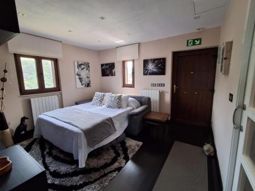 ein Schlafzimmer mit einem Bett und einer Couch in der Unterkunft Casa Pasarón in Luarca