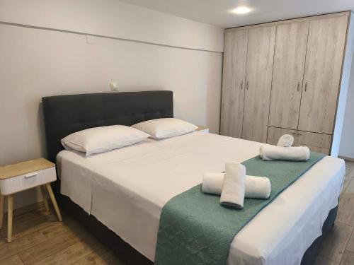 a bedroom with a large bed with towels on it at Villa Kazani by Karda Suites in Chios
