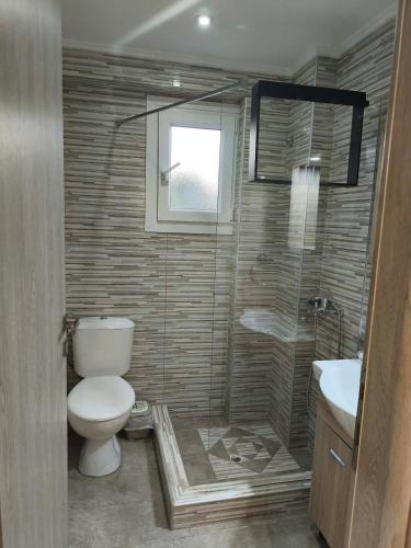 a bathroom with a toilet and a shower and a sink at Villa Kazani by Karda Suites in Chios