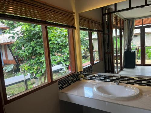 a bathroom with a sink and two windows at Slow Life Sabaidee Pai in Pai