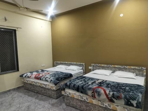 two beds sitting next to each other in a room at Hotel Shyam Vandan in Rīngas