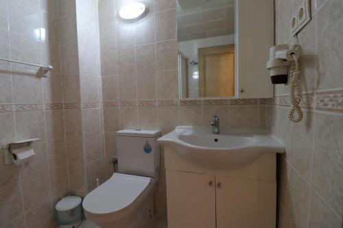 a bathroom with a toilet and a sink at Golden Moon Apart Hotel in Kuşadası