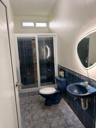 a bathroom with a toilet and a sink and a mirror at Dormilón in San Felipe