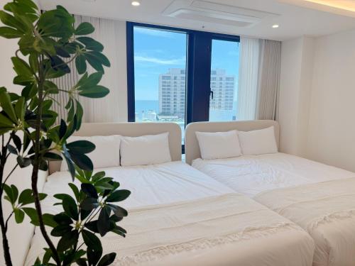 a living room with two beds and a large window at Stay in Waves in Ch'ŏngsap'o