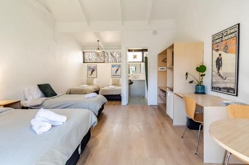 a room with two beds and a table and a dining room at Harrietville Hotel Motel in Harrietville