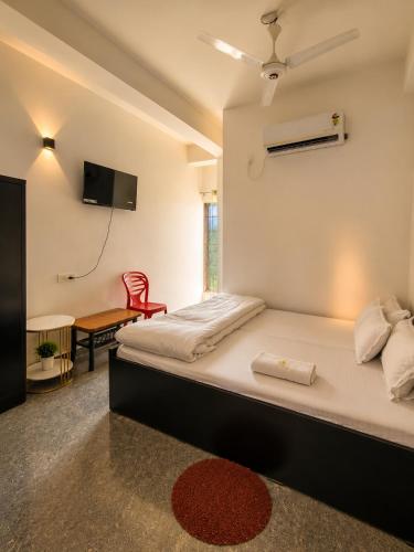 a bedroom with a bed and a table and a tv at White Lily in Guwahati