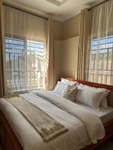 a bedroom with a large bed with a large window at Ngara Sleasure in Songea