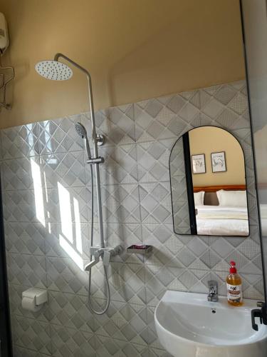 a bathroom with a shower and a sink and a mirror at Ngara Sleasure in Songea