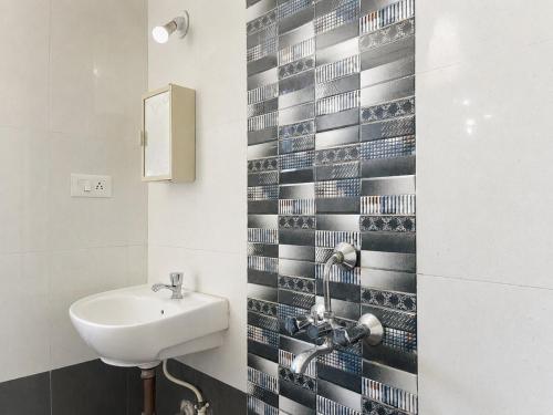 a bathroom with a sink and a mirror and a toilet at Casafern Homestay Goa in Varca