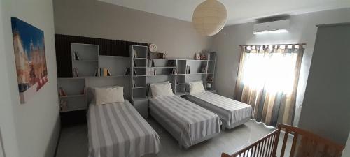 a bedroom with two beds and a shelf at Ramzam - Spacious & Modern 3 bedroom apartment with roof terrace in Marsaskala