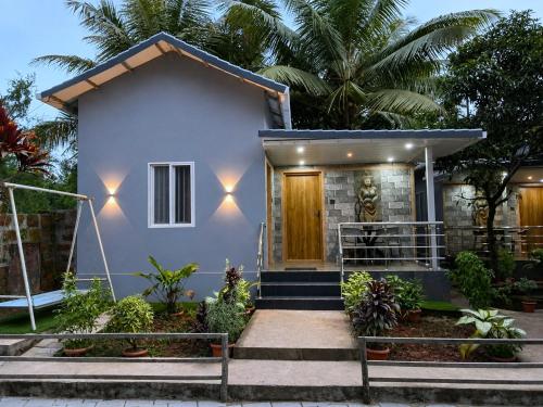 a house with a front entrance with two benches in front at Shilpa Serenity in Kāsarkod