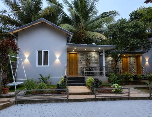 a white house with a palm tree at Shilpa Serenity in Kāsarkod
