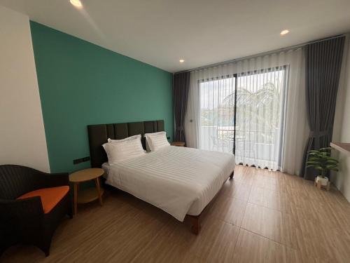 a bedroom with a white bed and a green wall at The Hidden Place Bangtao in Bang Tao Beach