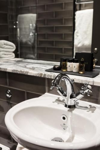 a bathroom with a white sink and a mirror at The Driftwood Bexhill in Bexhill
