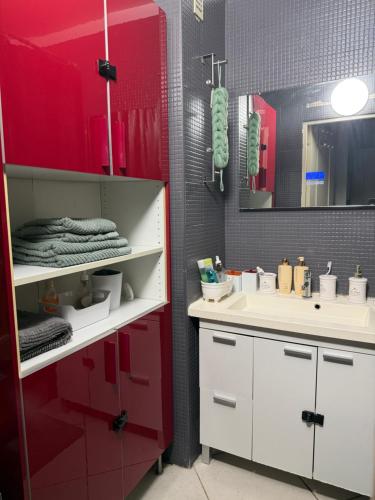 a bathroom with red and white cabinets and a sink at CHAMBRE dans appartement moderne guest house in Menton