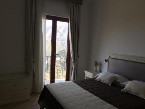 1 dormitorio con cama y ventana grande en Il Casale Del Mirto, en Vico Equense