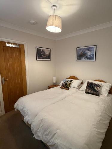 a bedroom with a large white bed with two pillows at No. 2 Watch House in Dawlish