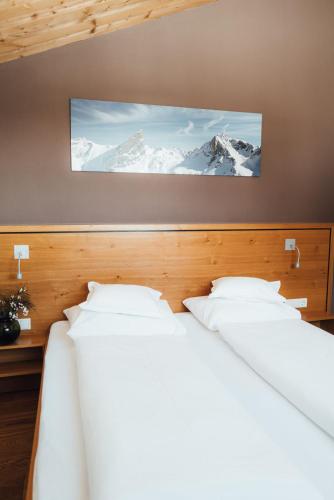two beds in a room with snow covered mountains at Das Tannberg in Lech am Arlberg