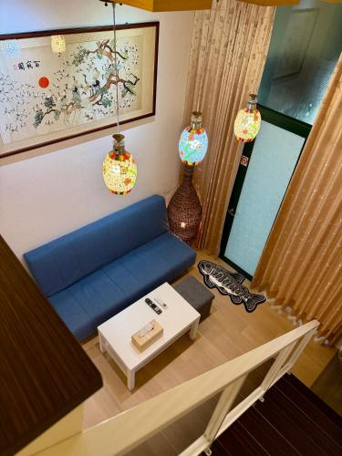 a living room with a blue couch and a table at 山下溫泉民宿 in Yü-shih-ts'un