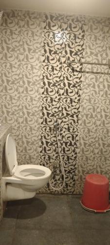 a bathroom with a toilet and a black and white wall at HoTEL RAJ VIHAR RESIDENCY in Vijayawāda