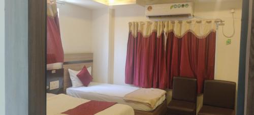 a small room with two beds and a curtain at HoTEL RAJ VIHAR RESIDENCY in Vijayawāda