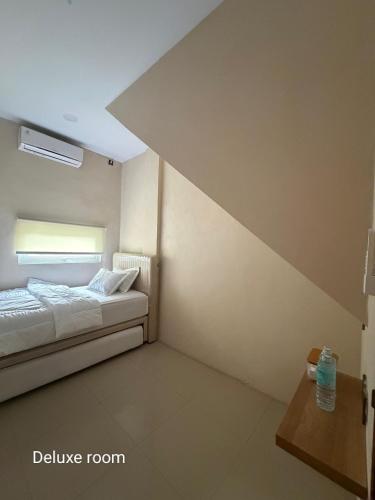 a small room with a bed and a window at Gassania Hostel in Banda Aceh