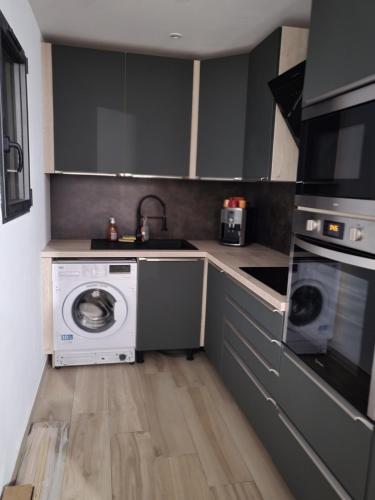 a kitchen with a washing machine and a washer at Valle du mezzane in Valle-di-Mezzana
