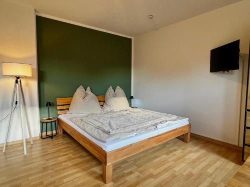 a bedroom with a bed with a green wall at Appartement Mari Lou in Ebermannstadt