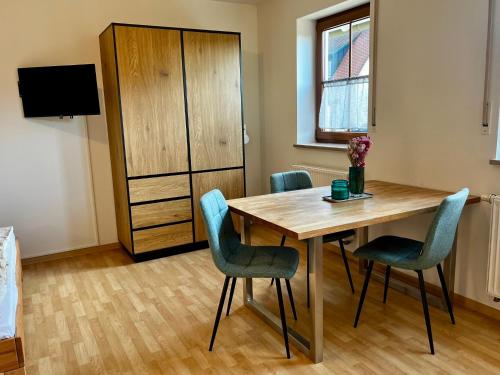 a room with a table and chairs and a television at Appartement Mari Lou in Ebermannstadt