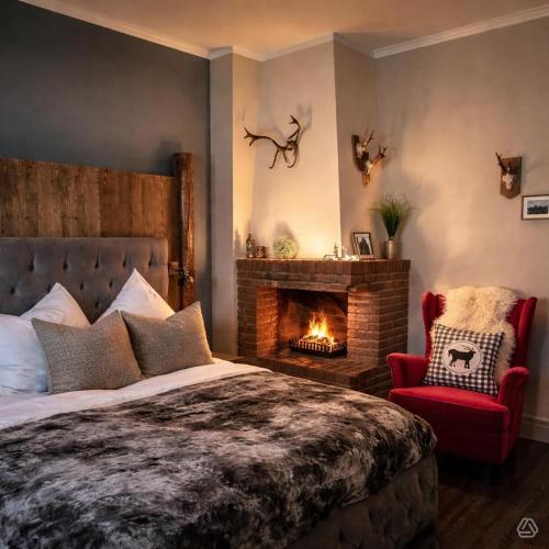 a bedroom with a bed and a fireplace at Hotel am Kurpark in Bad Lauterberg
