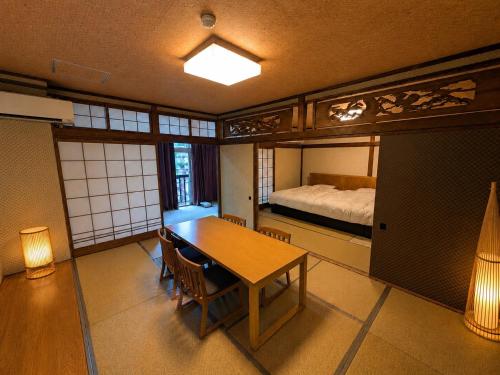 a room with a table and a bed and a bedroom at Atarayo Nishiizu Onsen in Ukusu