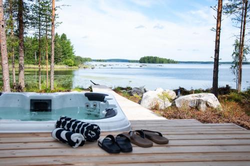 a bath tub sitting on a dock next to a body of water at Elon ranta in Alvajärvi