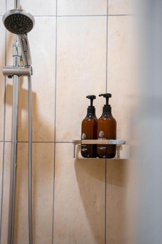 two bottles of soap sitting on a shelf in a bathroom at Shaheen Hotel Baghdad in Baghdād
